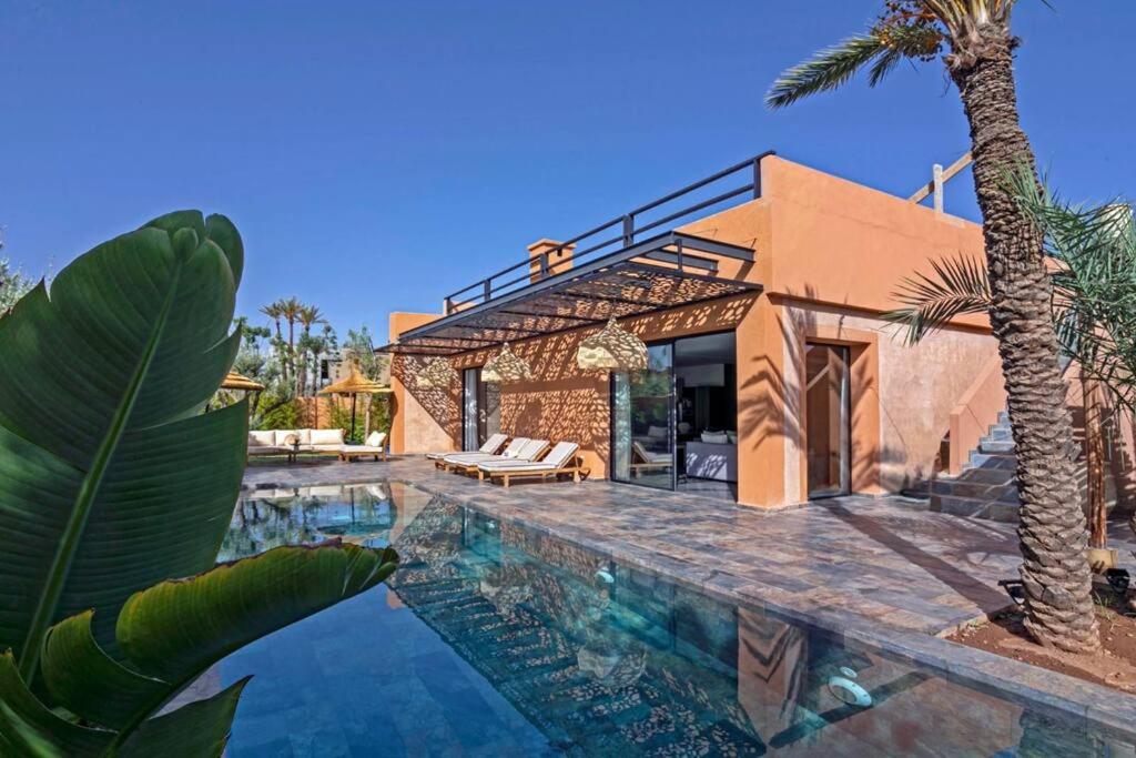 eine Villa mit einem Pool und einem Haus in der Unterkunft Villa 4 chambres - Piscine in Marrakesch