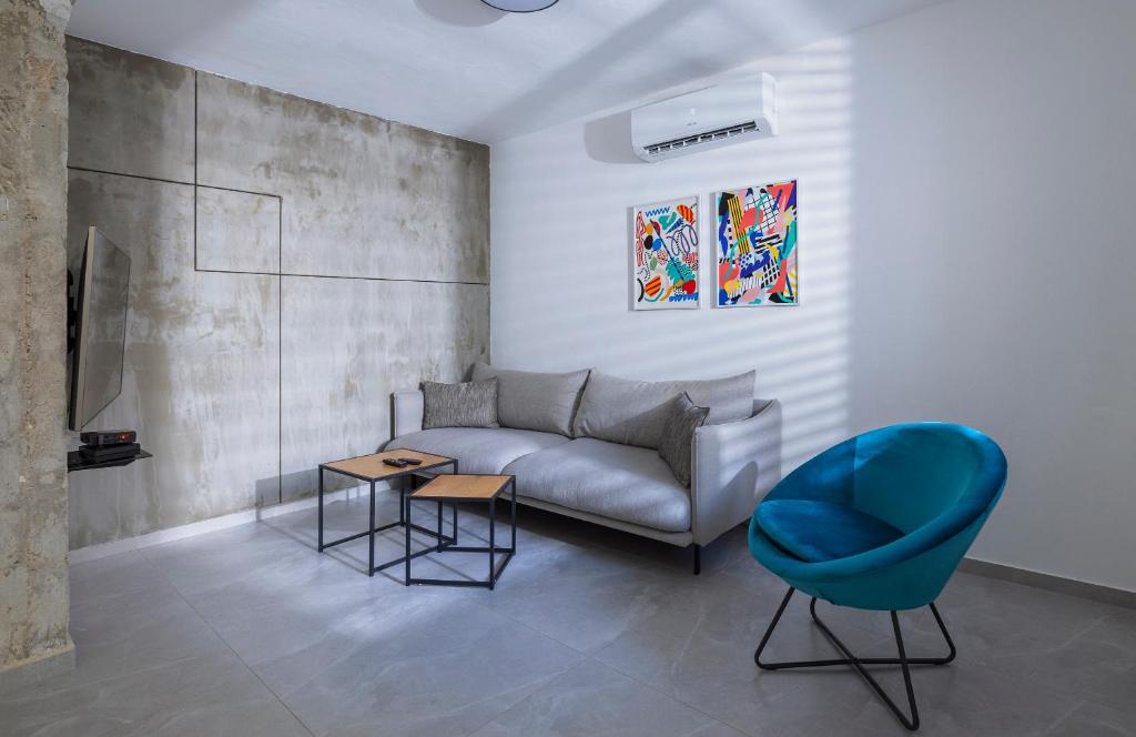 a living room with a couch and a blue chair at Alapark - MORE apartments in Beer Sheva