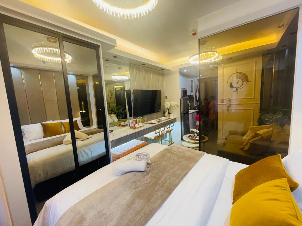 a bedroom with two beds and a large mirror at Yassi's Suite at MOA in Manila
