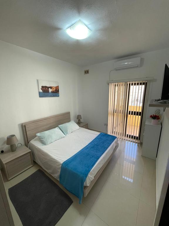 a bedroom with a bed and a television in it at SG seaview apartment in Xgħajra