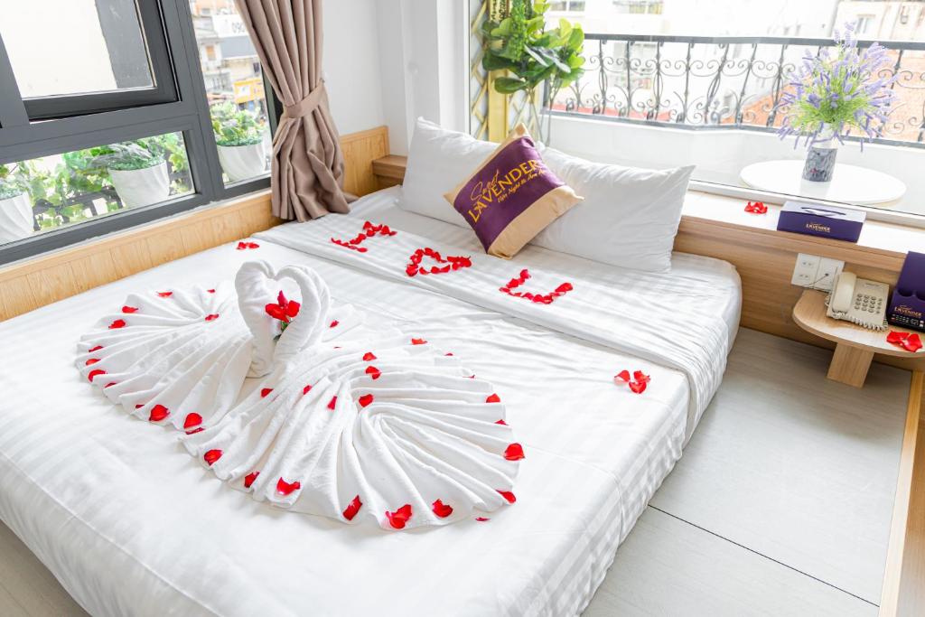 a bedroom with two beds with red flowers on them at Sweet Lavender Hotel - Near Dalat Night Market in Da Lat