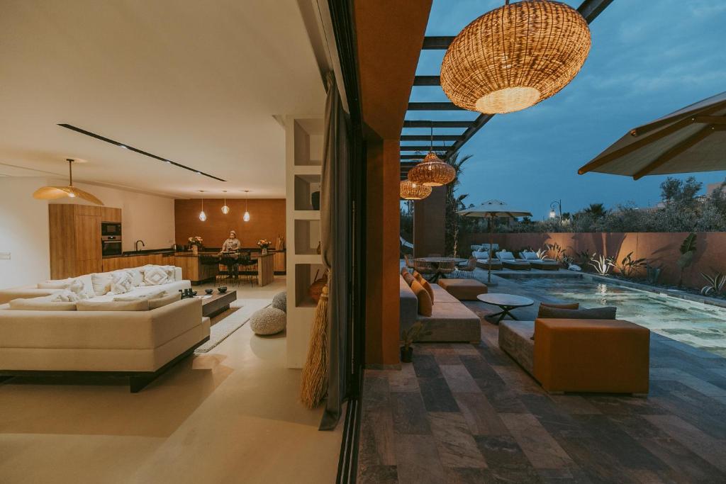 una sala de estar abierta con piscina y muebles en Villa 3 chambres Piscine - Golf, en Marrakech