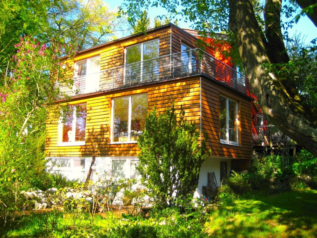 a wooden house with a balcony on top of it at Atelier Seeshaupt ruhige Oase zwischen den Seen in Seeshaupt