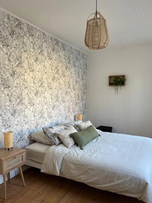 ein Schlafzimmer mit einem Bett und einem Wandbild in der Unterkunft Maison plein centre Sainte-Terre in Sainte-Terre