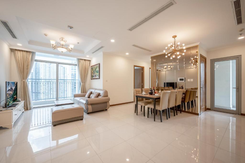 a living room and kitchen with a dining room and a dining table at LANDMARK PLUS RESIDENCES LUXURY SUITE in Ho Chi Minh City