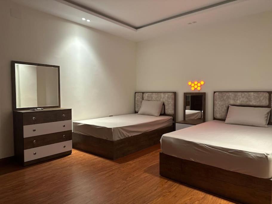 een slaapkamer met 2 bedden, een tv en een dressoir bij La Casa Luxurious Smart Home in Caïro