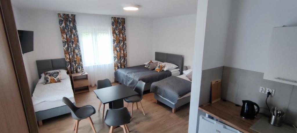 Habitación pequeña con 1 cama y 1 dormitorio con mesa. en Zakręt Solina 537-791-246, en Solina