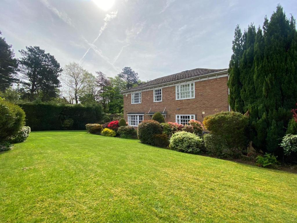a brick house with a large lawn in front of it at Spacious 4 Bedroom House with Garden and Parking in Ecclesall