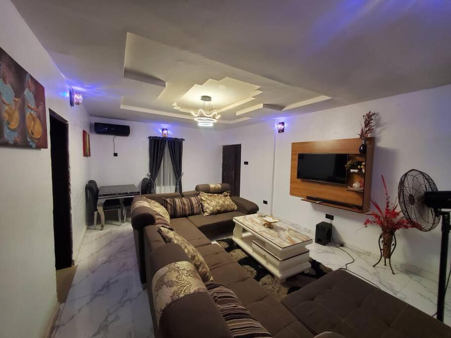 - un salon avec un canapé et une télévision dans l'établissement TSOLID HOMES, à Ibadan