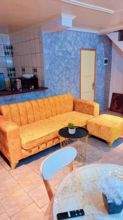 ein Wohnzimmer mit einem Sofa und 2 Tischen in der Unterkunft Appartements Benedicta in Libreville