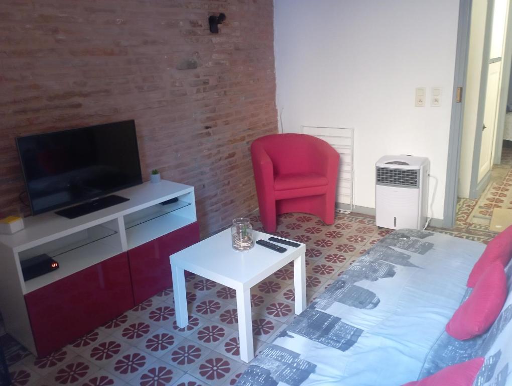 uma sala de estar com uma cama, uma televisão e uma cadeira em Maison entière Coeur village em Argelès-sur-Mer