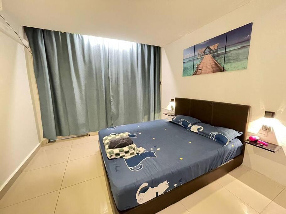 Un dormitorio con una cama con un edredón azul con una vaca. en KK City A2Z Api Api Modern Studio Homestay en Kota Kinabalu