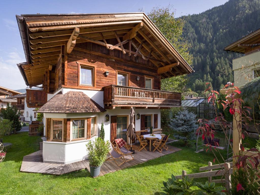 a log house with a deck and a patio at S'Dörfl Chalets in Mayrhofen