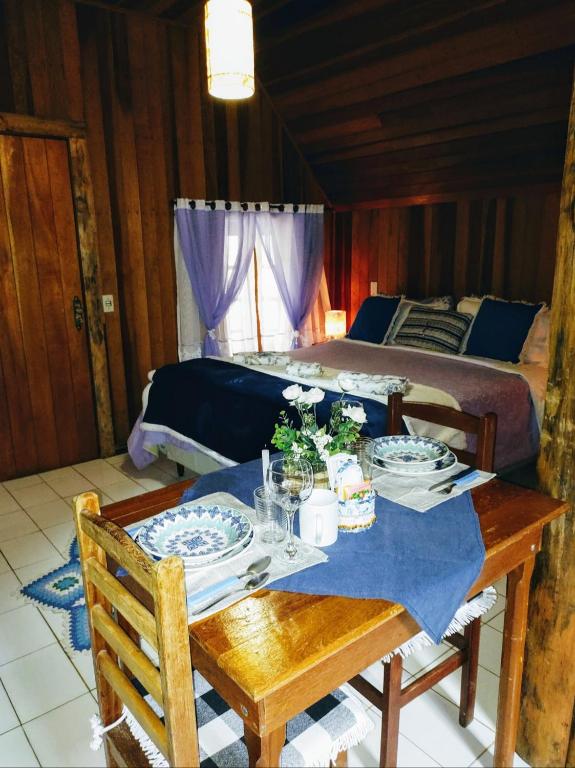 a dining room table with a bed in a bedroom at Pousada ao nascer do sol in Gonçalves