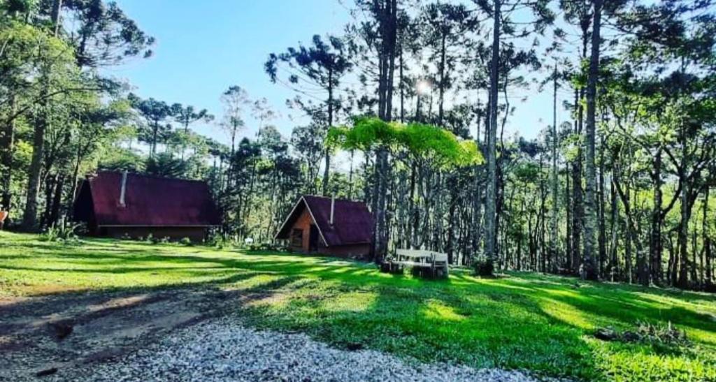 a barn in the middle of a field with trees at Pousada ao nascer do sol in Gonçalves