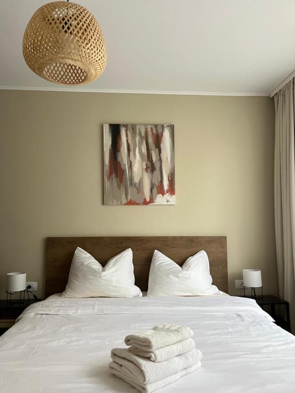 Un dormitorio con una cama blanca con toallas. en Igla House, en Baia Mare