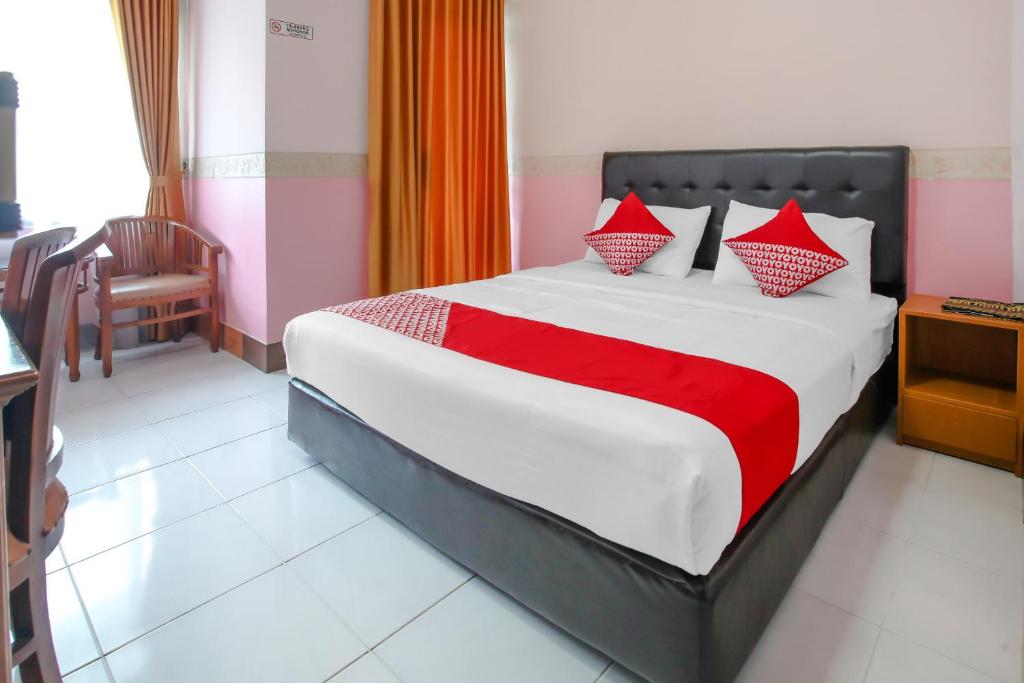 ein Schlafzimmer mit einem großen Bett mit roten Kissen in der Unterkunft OYO Life 90091 Wisma Pakuan Syariah in Bogor