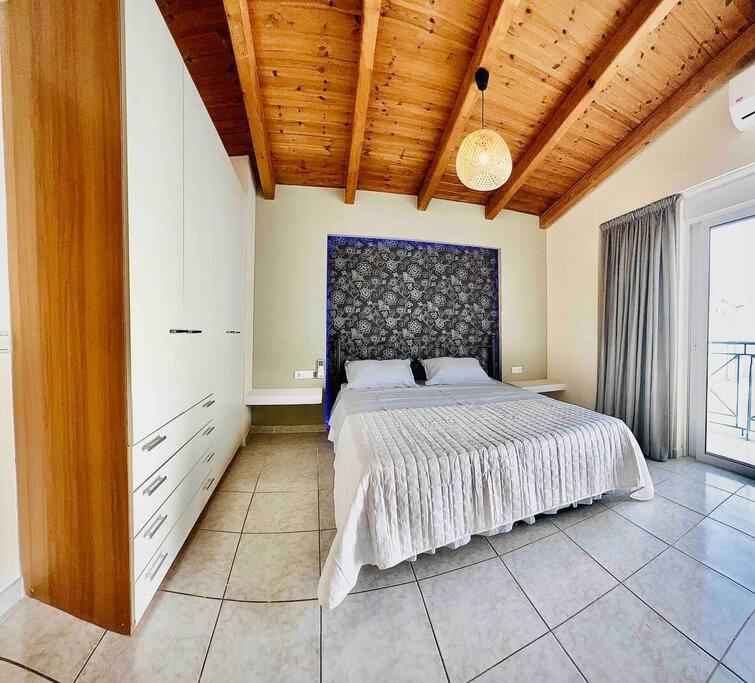 a bedroom with a large bed and a wooden ceiling at 3 Bedrooms Maisonette in Patra