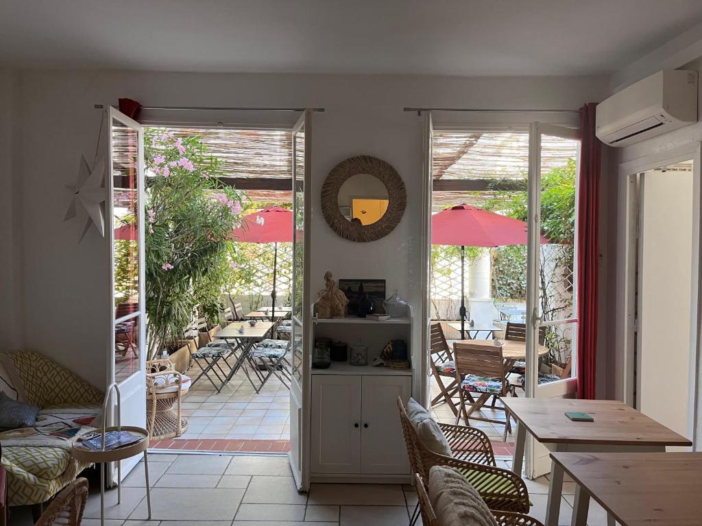 a living room with a table and chairs and a patio at Hôtel Eden - La Baigneuse in Juan-les-Pins