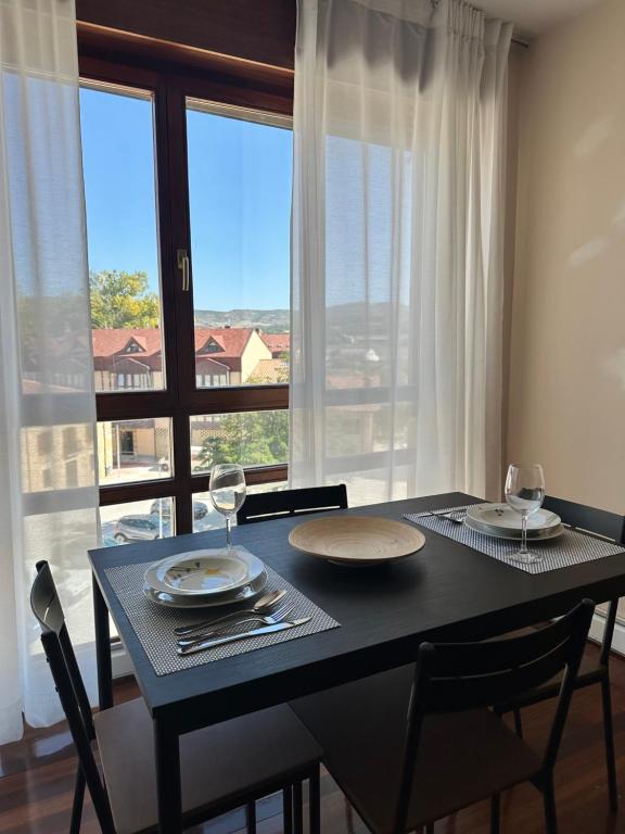 a dining room table with a view of a window at El rincón acogedor in Medina de Pomar