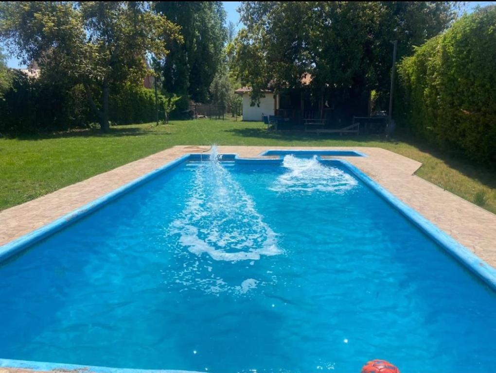 una piscina con acqua blu in un cortile di Casa con piscina mena a Los Andes