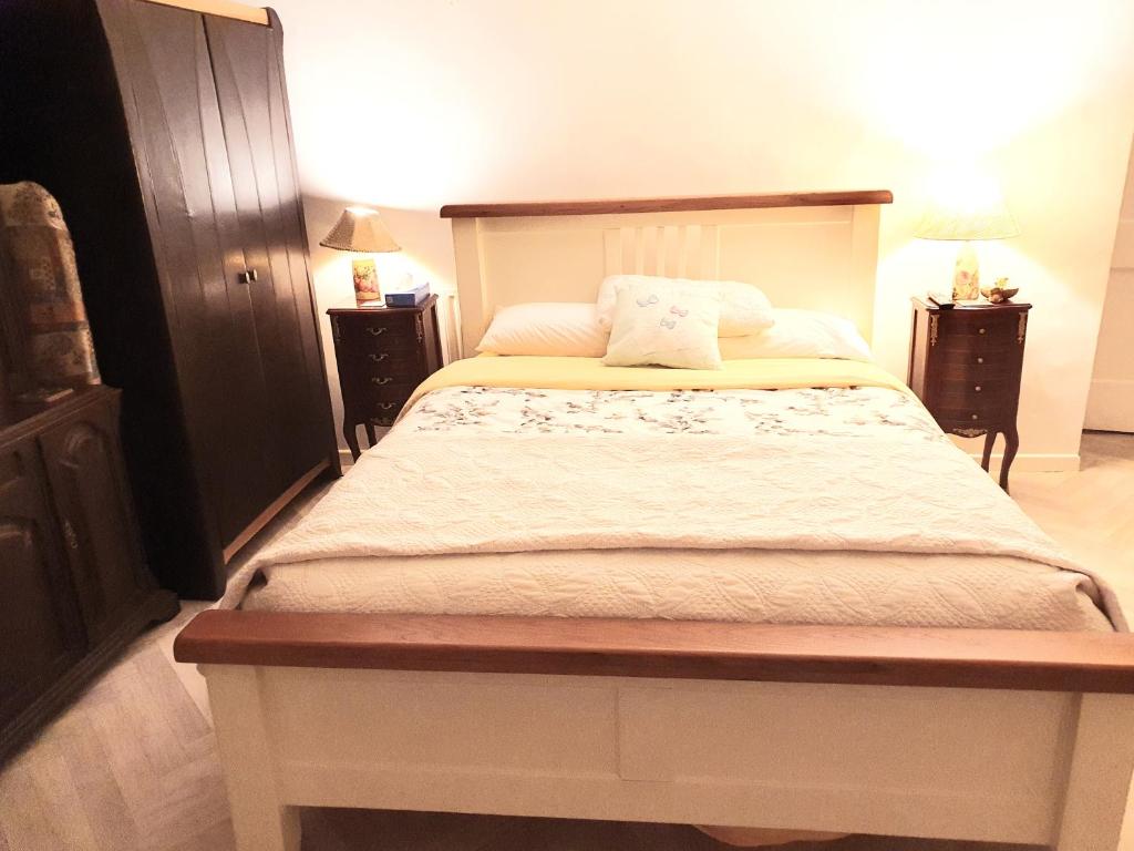 um quarto com uma cama grande e duas mesas de cabeceira em Bright Cottage, kingdom of mourne em Ballynoe