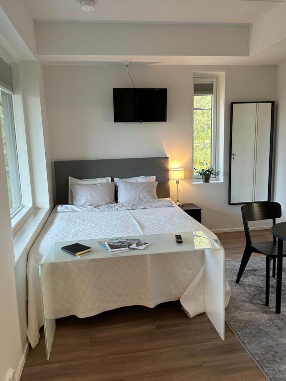 um quarto com uma grande cama branca e uma televisão na parede em Condo in the heart of Katariina, near Kotka City Center! em Kotka
