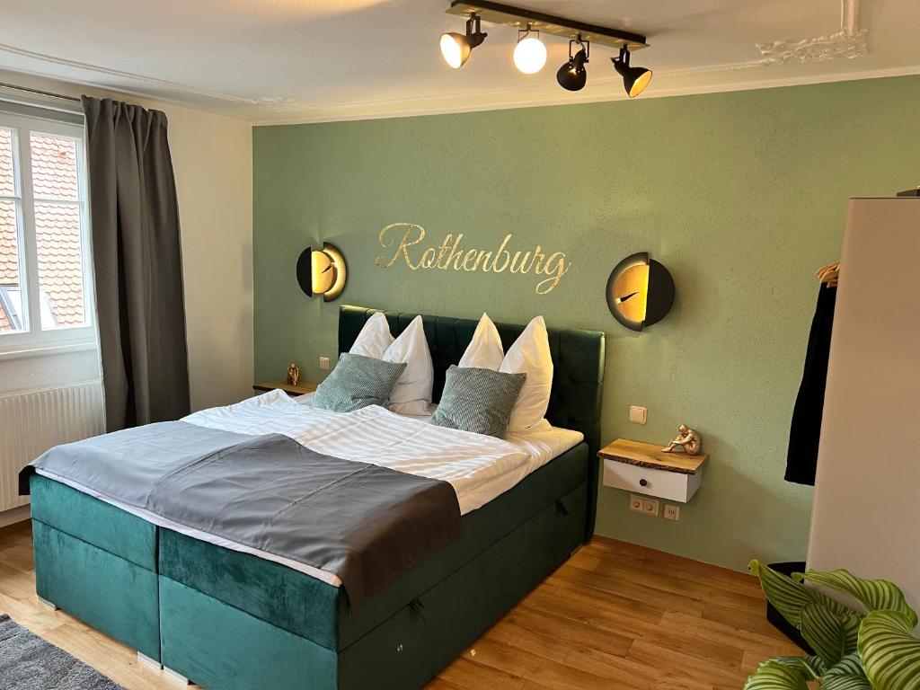 a bedroom with a bed with a sign on the wall at #Stadtspeicher - Grüner Stern das Apartment mitten in der Altstadt in Rothenburg ob der Tauber