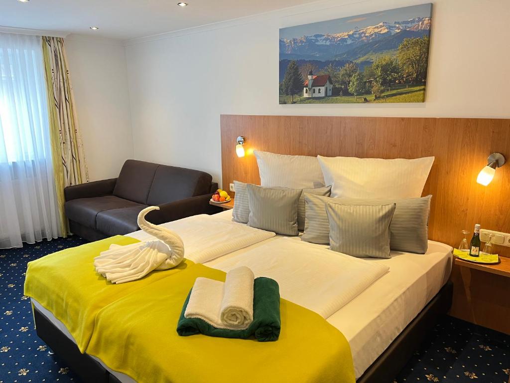 a hotel room with a bed and a couch at Hotel Post - regionales großes Frühstücksbuffet - auch GF & LF in Scheidegg