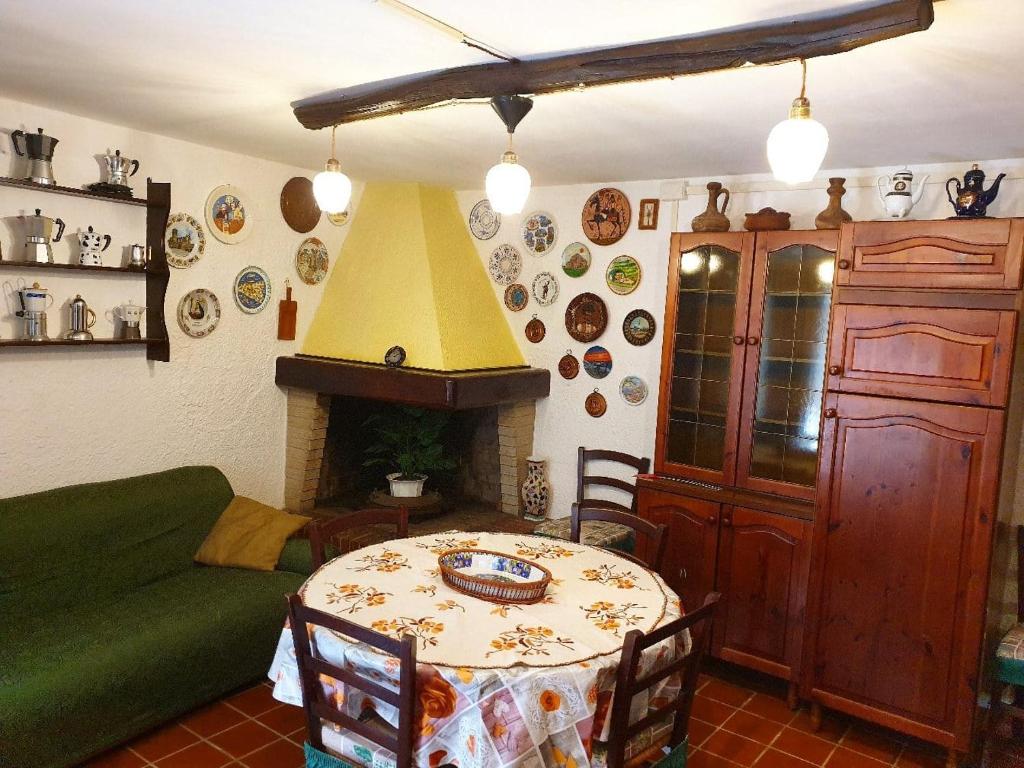 - un salon avec une table et une cheminée dans l'établissement Basement Home, à Domusnovas