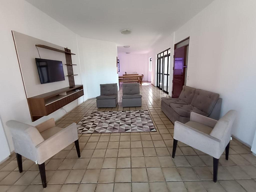 a living room with a couch and chairs and a tv at HostellHouse Márcia Guimarães in João Pessoa
