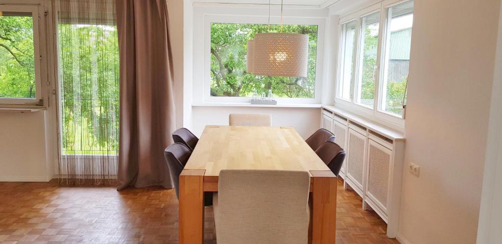 comedor con mesa de madera y 2 ventanas en Haus am Bodensee, en Fußach