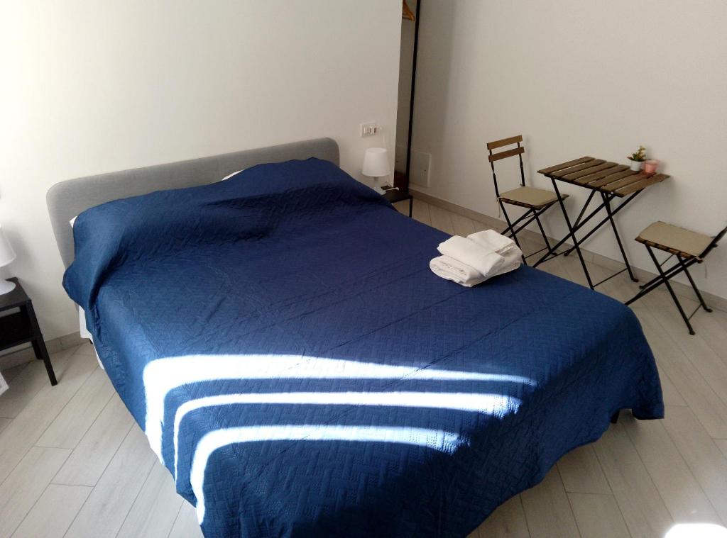 een blauw bed in een kamer met een tafel en stoelen bij Rooms add e criatur in Napels