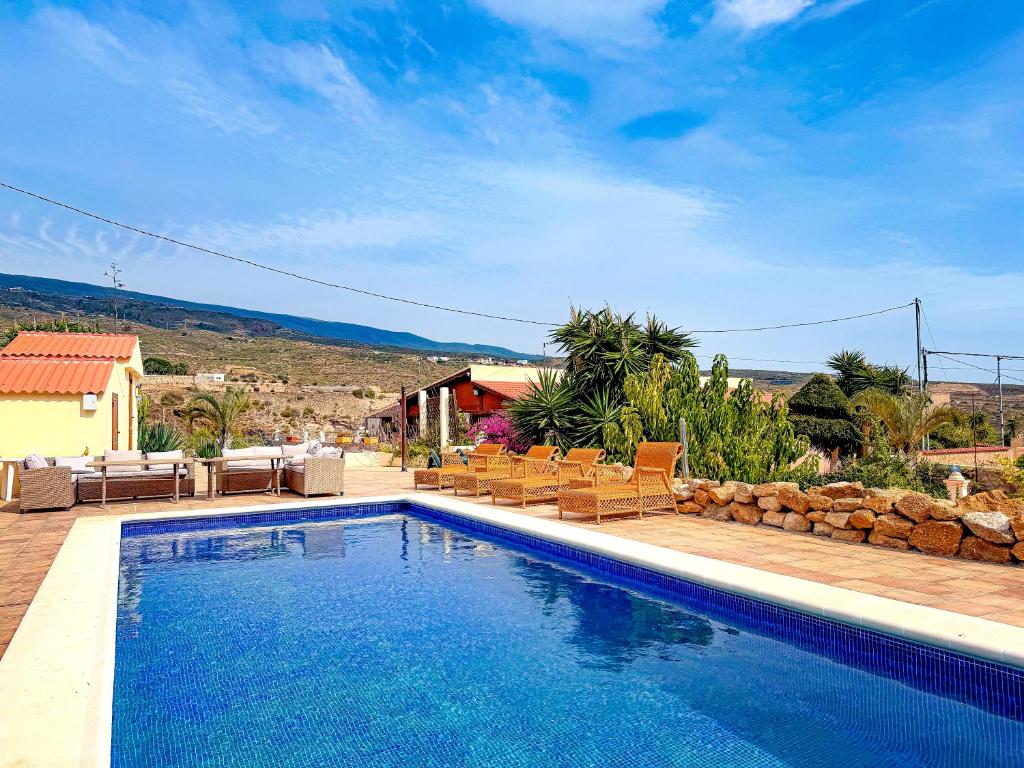 a swimming pool in front of a house at Exquisite rural house with garden, pool and sea views in Arico Viejo