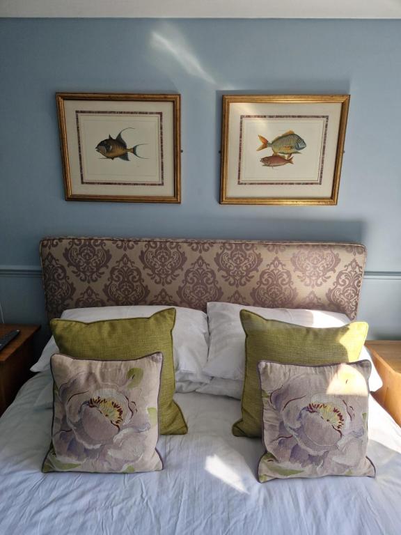 um quarto com uma cama com duas fotografias na parede em The Emsworth B&B Hotel em Emsworth