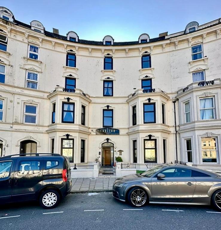 two cars parked in front of a large building at The Carlton's Holiday Suites in Bridlington