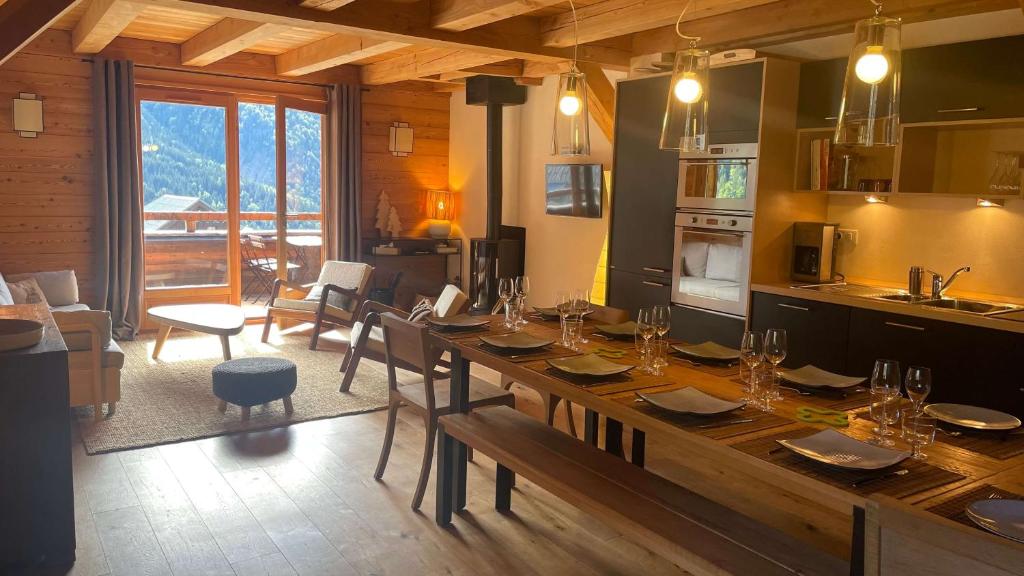 Chalet Skidh - 10 personnes - emplacement idéal au centre de Vaujany في فوياني: مطبخ وغرفة طعام مع طاولة خشبية كبيرة