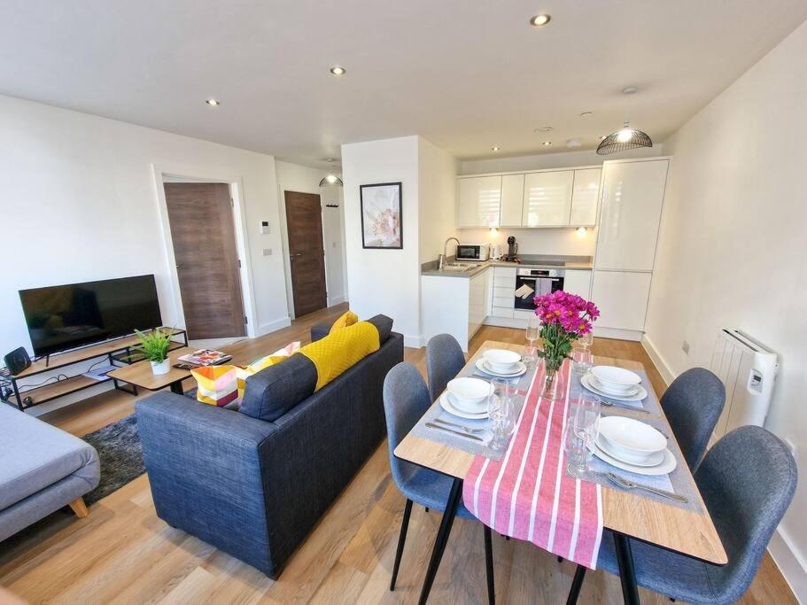 a living room with a couch and a table with chairs at Free Parking: Old Trafford Apartment in Manchester
