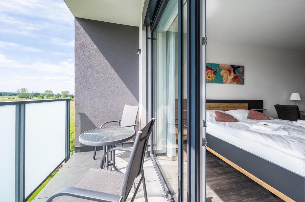 sypialnia z łóżkiem oraz balkon ze stołem i krzesłami w obiekcie RELAX PARK Třeboň II w Trzeboniu