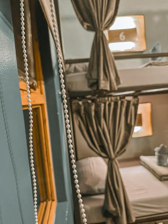 a mirror reflection of a bed in a room at Outpost Hostel - Coron in Coron