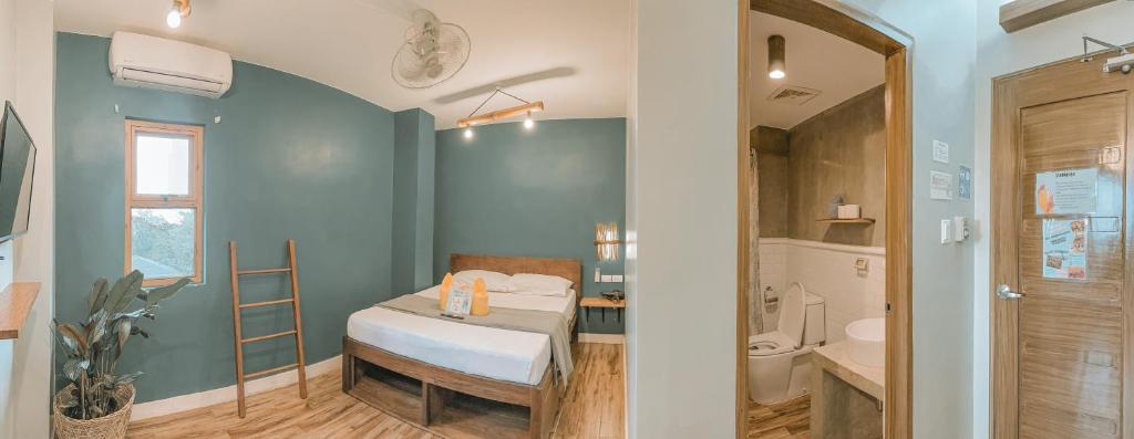 a small room with a bed and a bathroom at Outpost Hostel - Coron in Coron