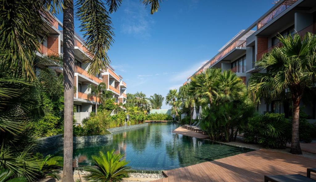 une piscine au milieu d'une cour avec des palmiers dans l'établissement Angkor Grace Residence & Wellness Resort, à Siem Reap