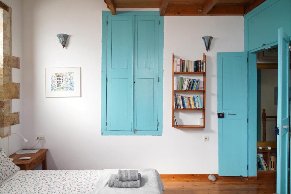 um quarto com portas azuis e uma estante de livros em Lindas Convent Garden Home 4 em Chania