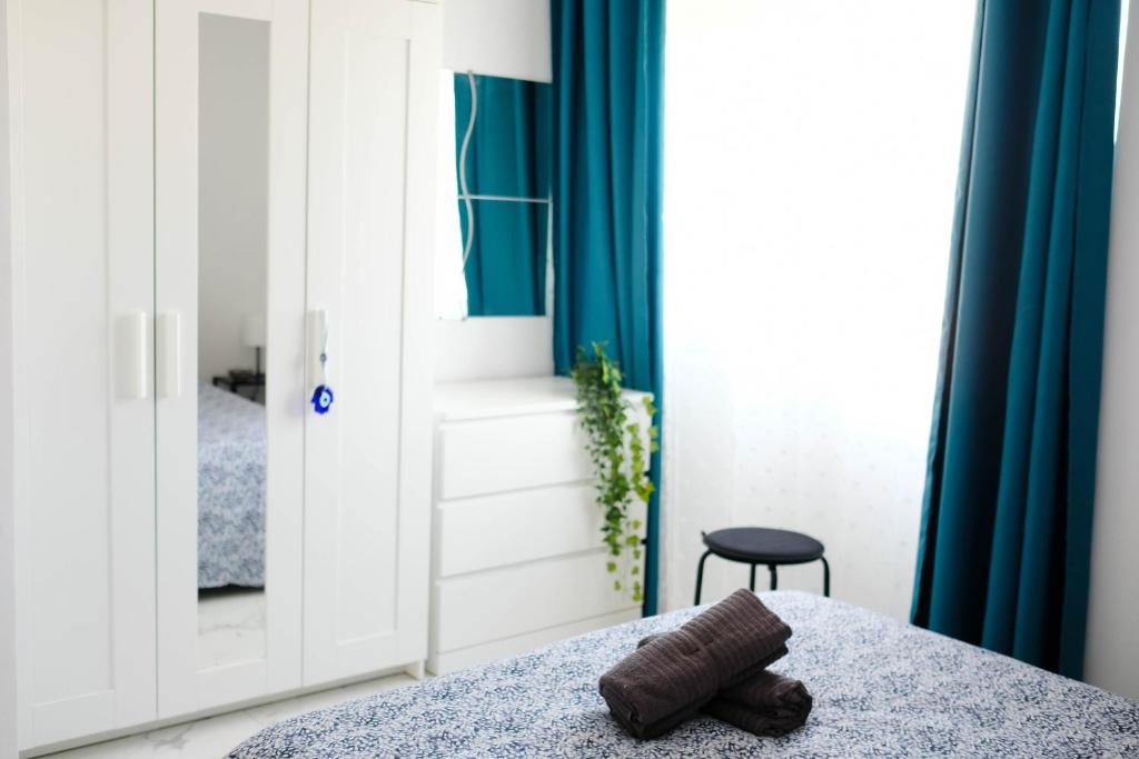 Schlafzimmer mit einem Bett mit blauen Vorhängen in der Unterkunft Lima Residence in Nikosia