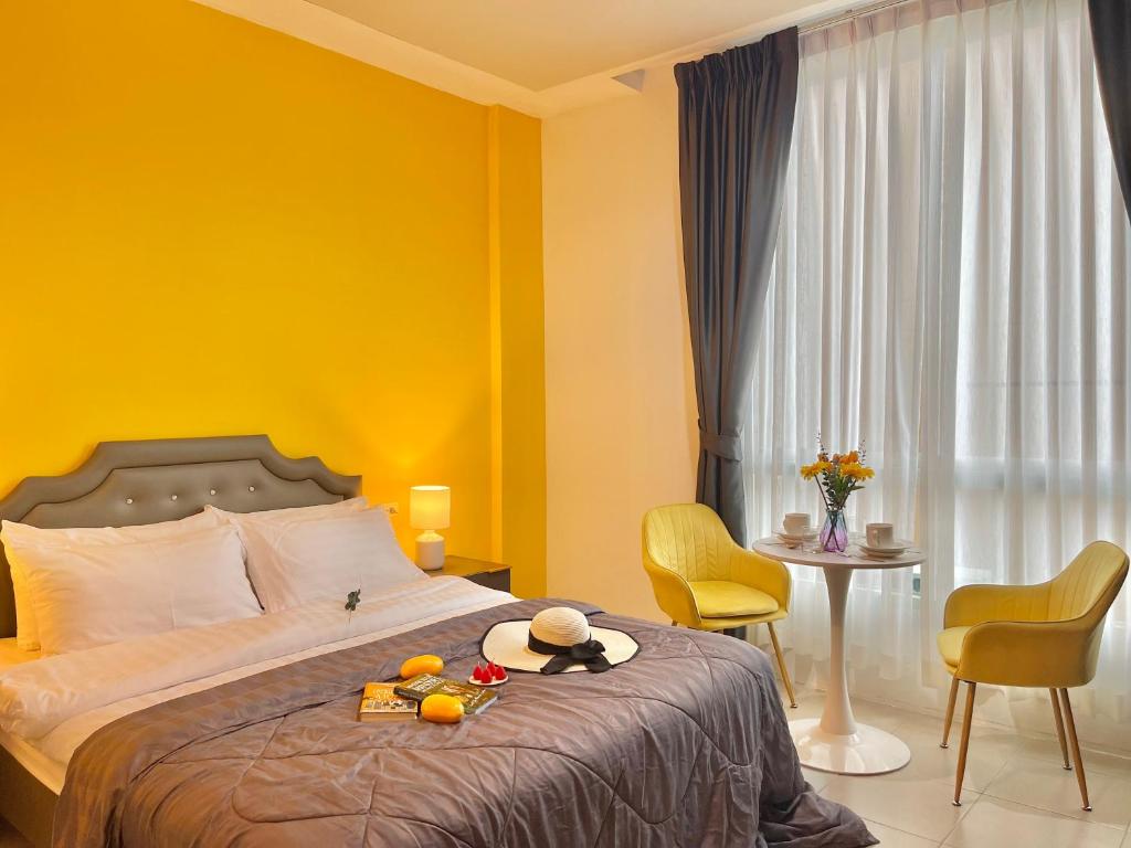 a bedroom with a bed with a yellow wall at Studio room in Mango House in Phuket Town