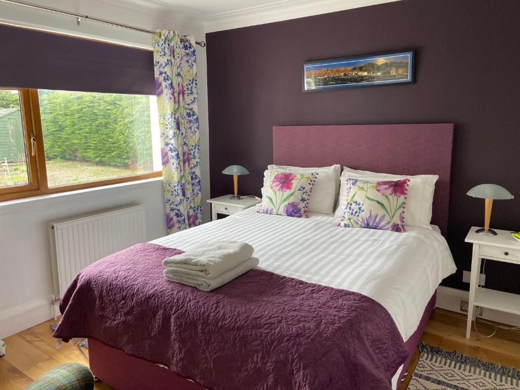 a bedroom with a purple bed with a purple blanket at 26 Green Drive Inverness in Inshes