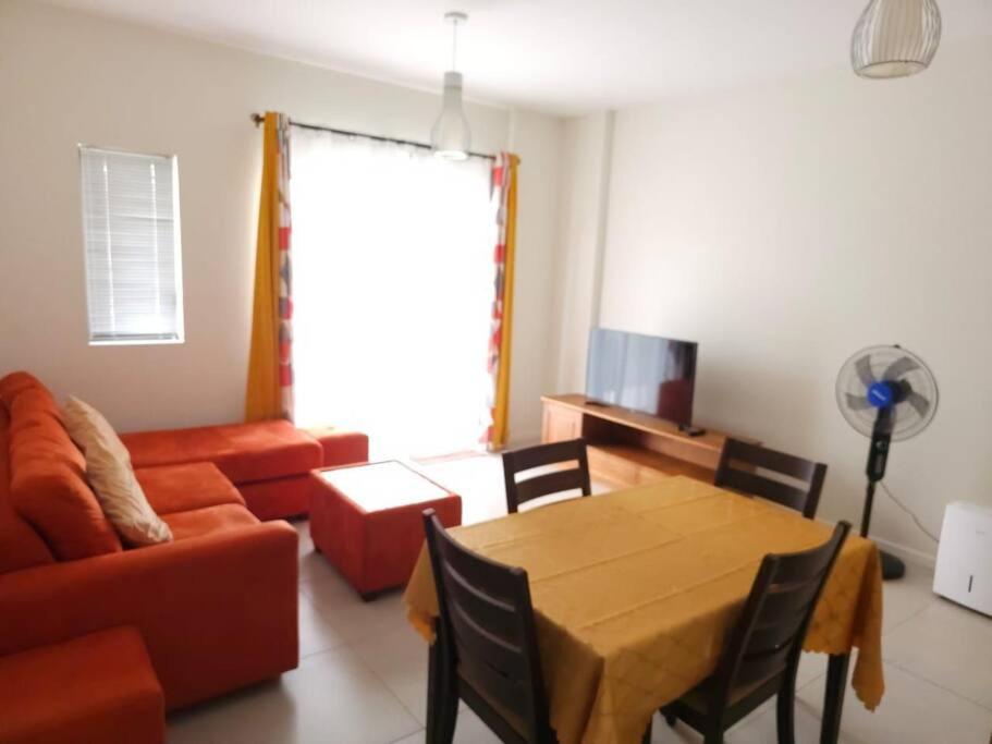 a living room with a table and a couch at Amazing 2 bedrooms with garden in Quatre Bornes