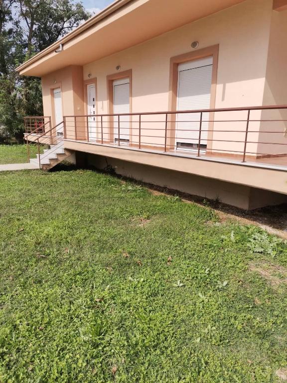a house with a balcony and a grass yard at Cozy Nook Cottage in Faneroméni