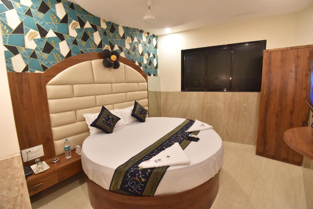 a bedroom with a large bed with a tv on the wall at Hotel Dream Palace Residency - Near LBS Marg Kural West in Mumbai