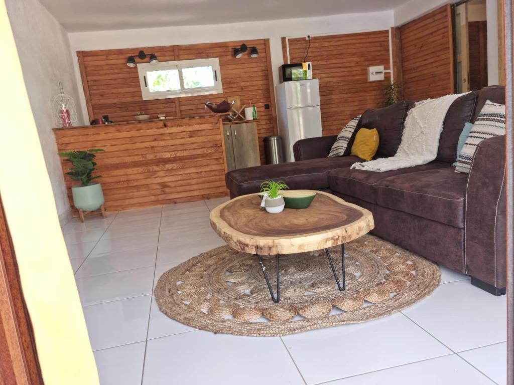een woonkamer met een bank en een salontafel bij Le chal'heureux in Chirongui
